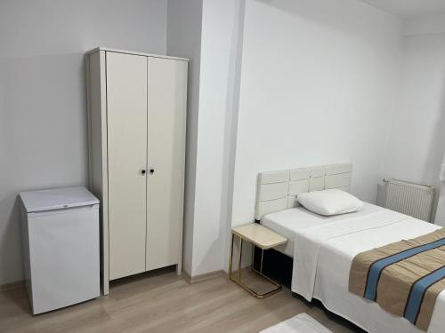 a small bedroom with a bed and a cabinet at Türkmen hotel in Istanbul
