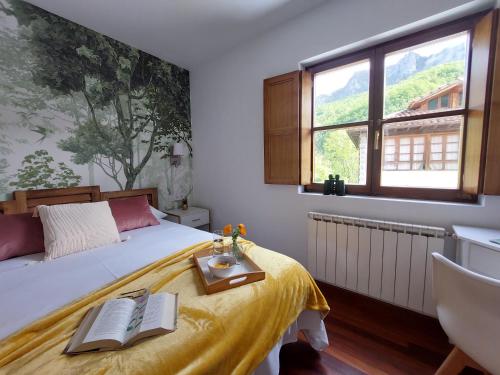 Un dormitorio con una cama con una mesa con un libro. en Apartamentos Nevandi, en Pido