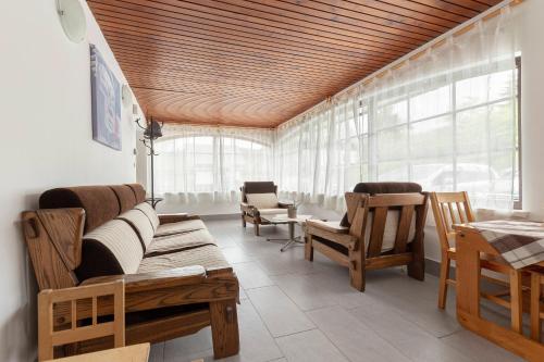 a living room with a couch and chairs and windows at Apartments Bor in Bohinj