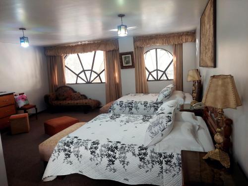 a bedroom with two beds and two windows at Maison plaza in Arequipa