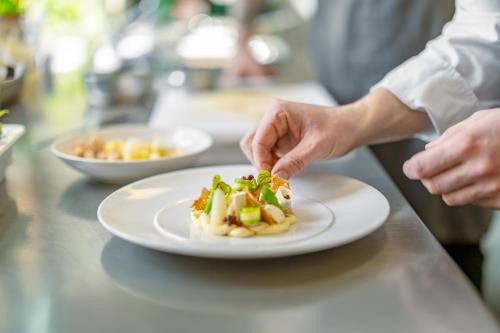 a person eating a plate of food on a counter at Hotel & Restaurant Michaelis in Leipzig
