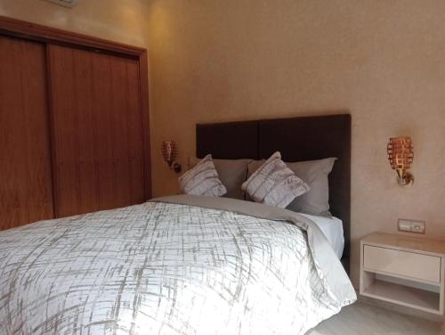 a bedroom with a large bed with white sheets and pillows at Babylone Marrakech in Marrakech