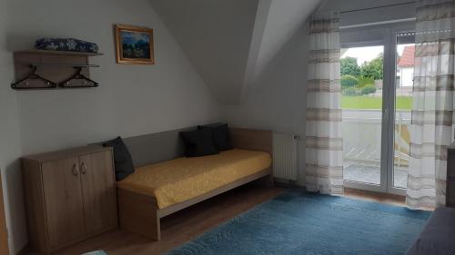 un piccolo letto in una camera con finestra di Privatzimmer a Burgau