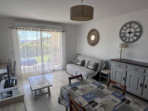 un salon avec un canapé et une table dans l'établissement Appartement T2 avec Jardin Privatif et Piscine, à 130m de la Plage - Les Issambres - FR-1-768-41, aux Issambres