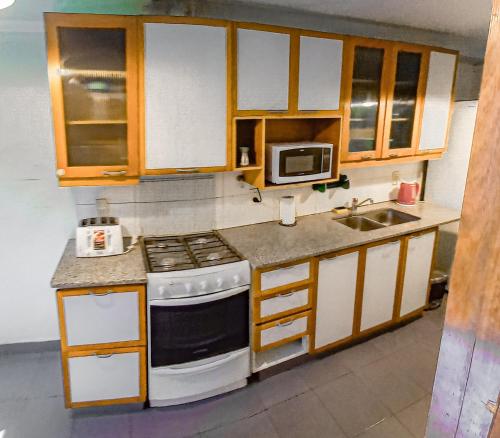 een keuken met een fornuis en een magnetron bij Casa Avellaneda in Mendoza