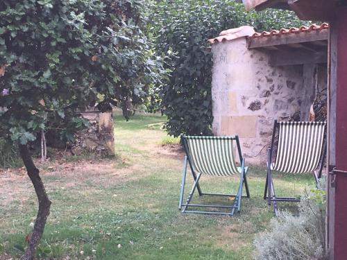 twee stoelen in het gras in een tuin bij Au cœur du jardin in Souvigné