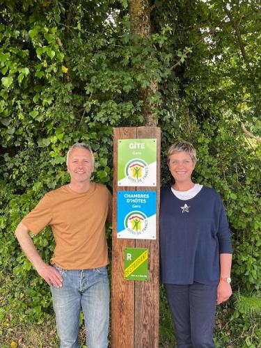 a man and a woman standing next to a sign at Clos Baroanni - Gîte Terra in Terraube