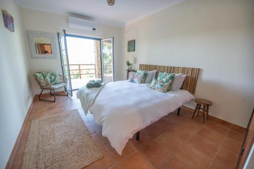 ein Schlafzimmer mit einem weißen Bett mit Kissen darauf in der Unterkunft The Art House in Serra