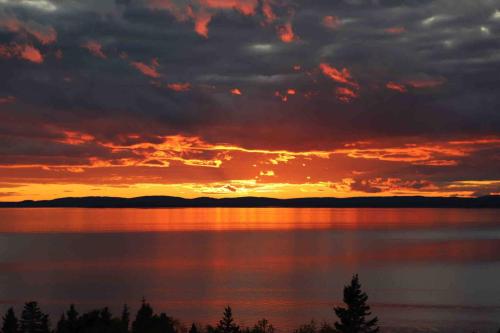 a sunset over a large body of water at The Carriage House - Tranquility With A View in LʼEtête