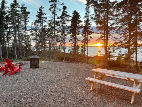 a group of picnic tables with the sunset in the background at The Carriage House - Tranquility With A View in LʼEtête