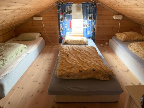 a room with three beds in a attic at Voss Resort self-service apartments in Skulestadmo