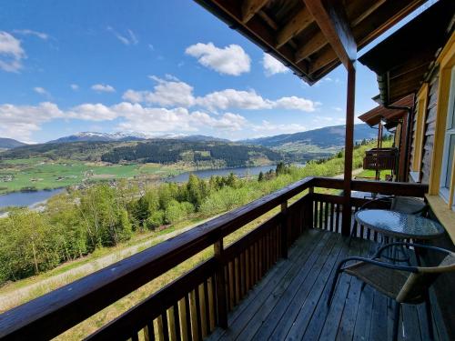 uma varanda com vista para um rio e para as montanhas em Voss Resort Bavallstunet em Skulestadmo