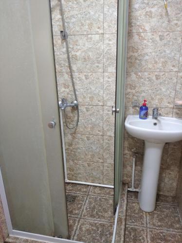 a bathroom with a shower and a sink at ТИФАНИ - дом с бассейном у речки in Bjni