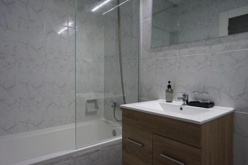 a white bathroom with a sink and a shower at Hotel Teide in El Arenal