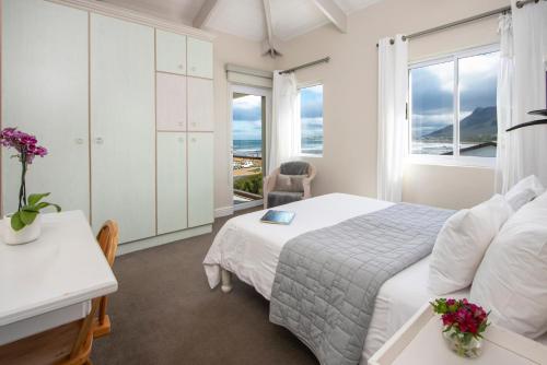 a white bedroom with a bed and a window at 138 Marine Beachfront Guesthouse in Hermanus
