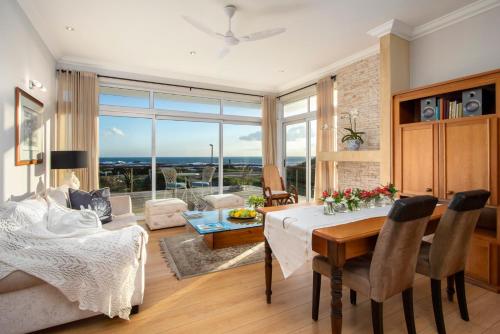 a dining room and living room with a table and chairs at 138 Marine Beachfront Guesthouse in Hermanus