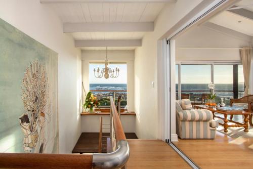 a living room with a chandelier and a dining room at 138 Marine Beachfront Guesthouse in Hermanus