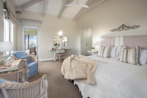 a bedroom with a large bed and a living room at 138 Marine Beachfront Guesthouse in Hermanus