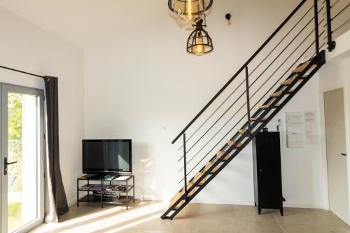 a staircase in a living room with a tv at côté verdon 1 in Quinson