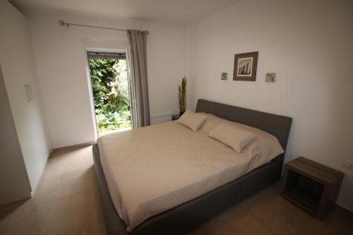 a small bedroom with a bed with a window at Apartment Umag in Umag