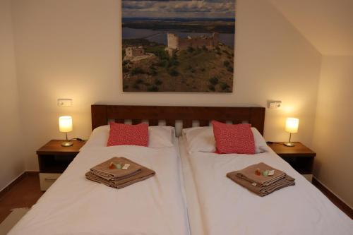 a bedroom with two beds with towels and two lamps at Pension Florián in Pavlov