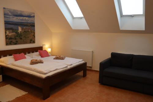 a bedroom with a bed and a couch and skylights at Pension Florián in Pavlov