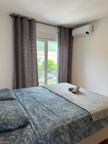 a bedroom with a large bed with a large window at Nonna Marija in Kotor