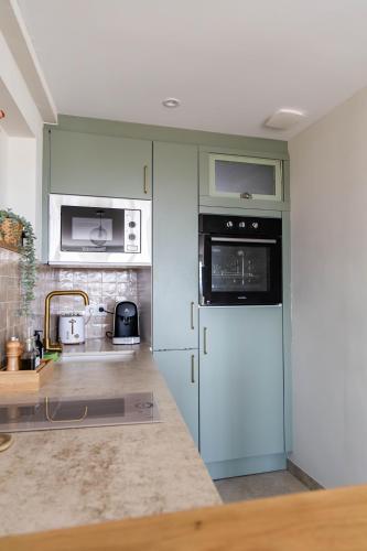 La cuisine est équipée d'un réfrigérateur blanc et d'un four micro-ondes. dans l'établissement VUE 180°, superbe appartement cocooning !, à Laroque-des-Albères