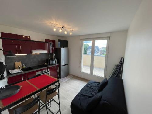- une cuisine avec un canapé et une table dans une chambre dans l'établissement Persea YourHostHelper, à Ouistreham