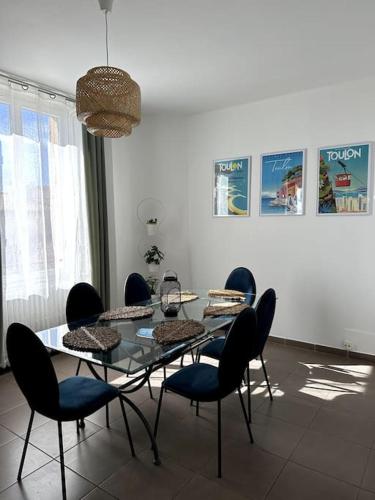 une salle à manger avec une table et des chaises en verre dans l'établissement Bel et grand appartement-Proche toutes commodités, à Toulon