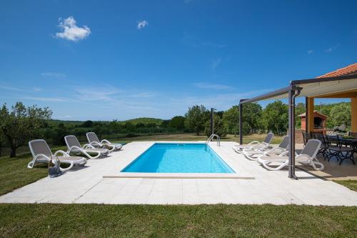 a swimming pool with lounge chairs and a table at Villa Jana in Rovinj