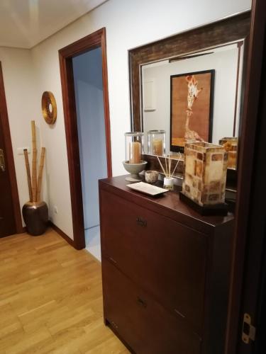 a dresser in a living room with a mirror at Pombal Bayona in Baiona