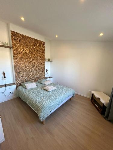 a bedroom with a bed and a brick wall at coté verdon 2 in Quinson