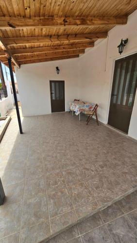 a large patio with a wooden ceiling and a table at Maria's place Agkistri in Megalochori