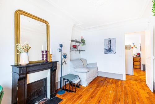 un salon avec une cheminée et un miroir dans l'établissement GuestReady - Peace and Comfort near Père-Lachaise, à Paris