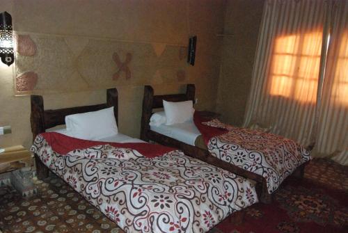 two beds in a hotel room with at Hotel Taddart in Midelt