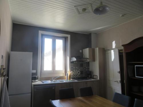 - une cuisine avec une fenêtre, un évier et une table dans l'établissement Les gites de Marcel, à Marcillac-la-Croisille