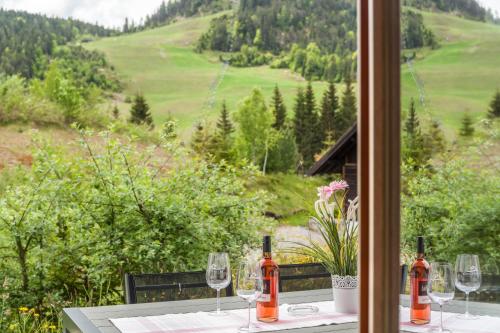 a table with wine glasses and a view of a valley at Mountainlodge in Leutasch