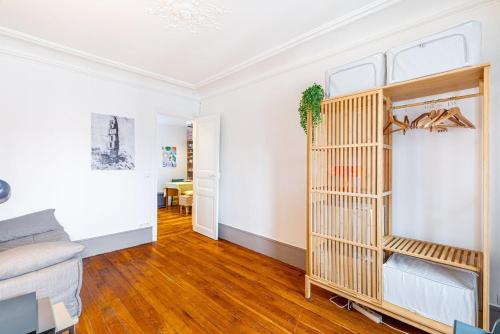 Il comprend un salon doté de murs blancs et de parquet. dans l'établissement GuestReady - Peace and Comfort near Père-Lachaise, à Paris