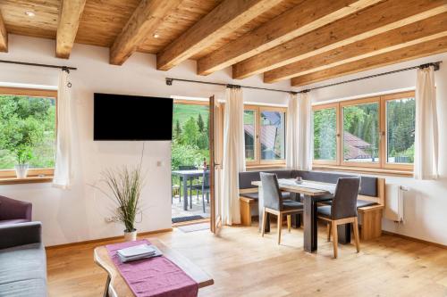 a living room with a table and chairs and windows at Mountainlodge in Leutasch