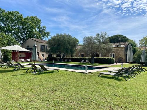 a group of lawn chairs and a swimming pool at Hôtel & Restaurant de charme - La Bégude Saint-Pierre in Vers Pont du Gard