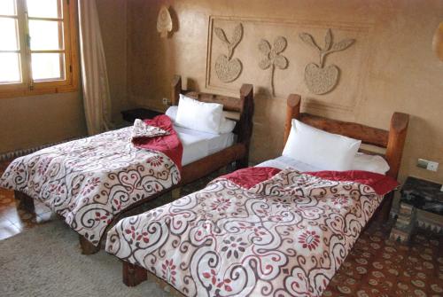 two beds in a hotel room with at Hotel Taddart in Midelt