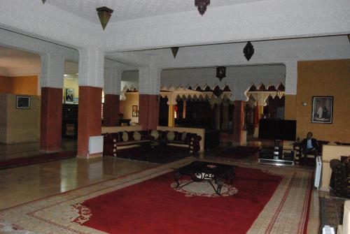 a large living room with a couch and a television at Hotel Taddart in Midelt