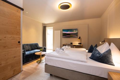 a hotel room with a large bed and a chair at Hotel Zum Mohren in Reutte