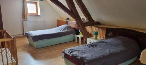 Zimmer im Dachgeschoss mit 2 Betten und einem Fenster in der Unterkunft Grand gîte à la campagne in Missé