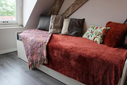 a bedroom with a bed with a red blanket and pillows at Luxurious and spacious apartment in historic building in Vianen