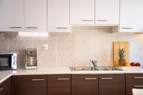 a kitchen with a sink and a microwave at Veloudi's Apartment 1 in Megalochori