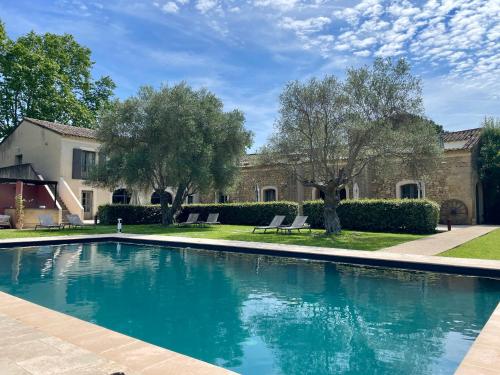 a swimming pool in front of a house at Hôtel & Restaurant de charme - La Bégude Saint-Pierre in Vers Pont du Gard