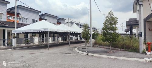 依斯干達的住宿－Raihan Homestay Seri Iskandar Perak Near UTP UITM，一条街道,有一排房子,有白色的伞
