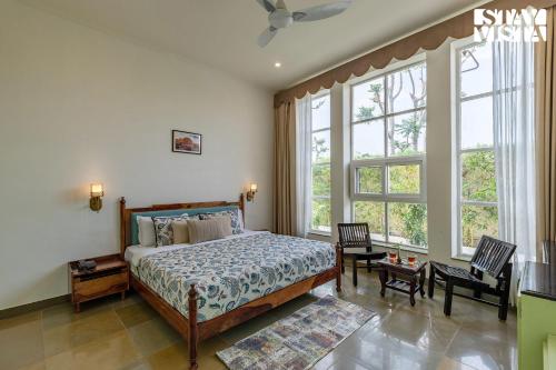 a bedroom with a bed and a large window at The Pastel Courtyard with Pvt Pool & Garden at Jaipur by StayVista in Jaipur